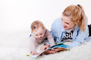 Frau schaut mit Kind ein Bilderbuch